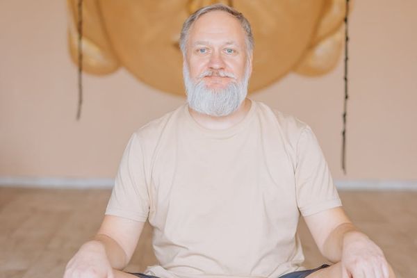 A person meditating on a yoga mat with a serene expression.